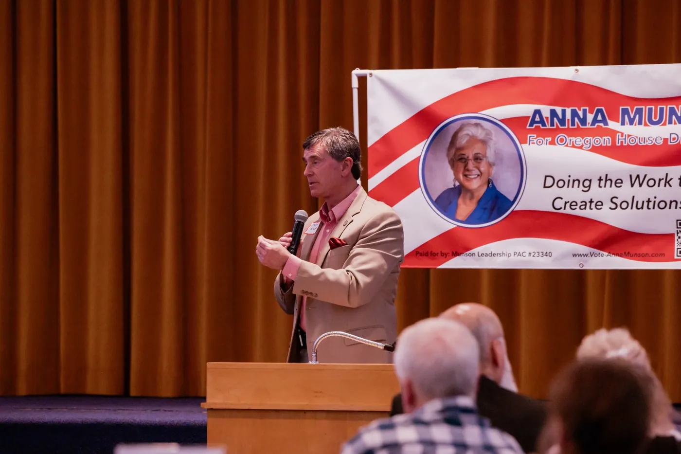 Jeff Kropf speaking at a podium beside the Anna Munson banner